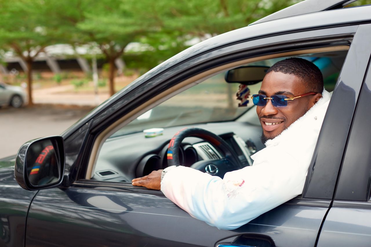 A smiling driver seated in a private car